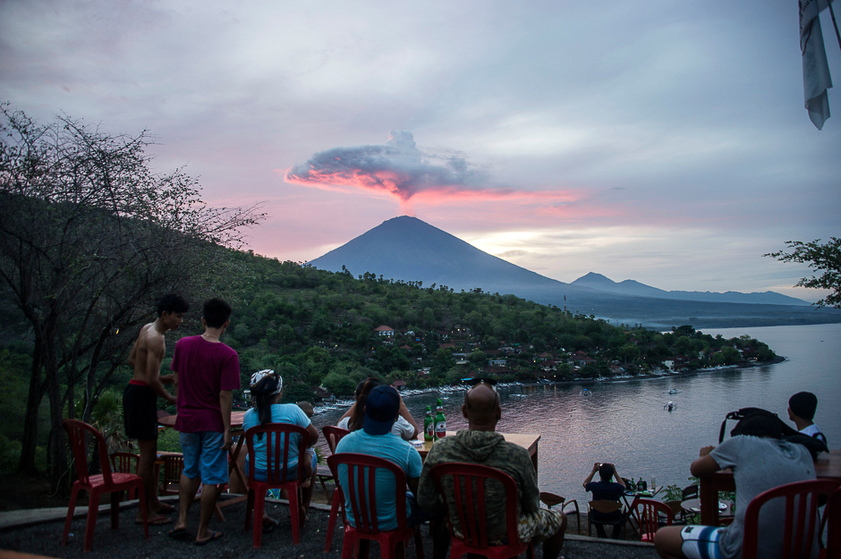 Tourists gather to watch Mount Agung at Amed beach in Karangasem on Indonesia's resort island of Bali. PHOTO: AFP