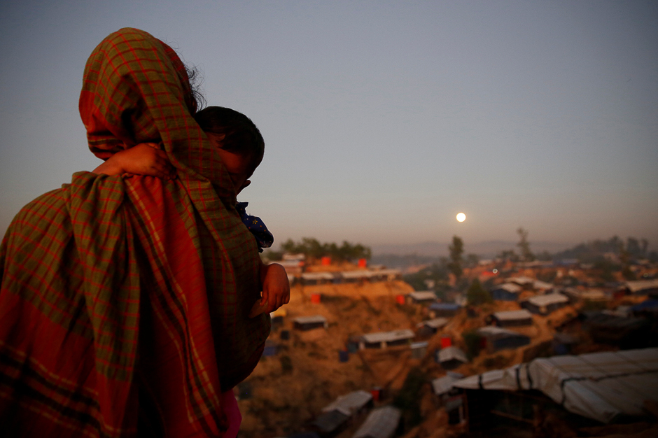 A Rohingya refugee looks at the full moon with a child in tow at Balukhali refugee camp near Cox's Bazar, Bangladesh. PHOTO: REUTERS
