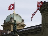 workers-hang-up-a-swiss-flag-on-the-swiss-parliament-building-in-bern