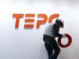 a-worker-puts-up-new-logo-of-tepco-holdings-and-tokyo-electric-power-company-group-on-the-wall-ahead-of-the-transition-to-a-holding-company-system-through-a-company-split-at-the-tepco-headquarters-in