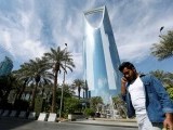 file-photo-a-man-speaks-on-the-phone-as-he-walks-past-the-kingdom-centre-tower-in-riyadh