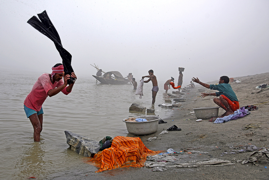 People wash clothes on the banks of the river Brahmaputra on a foggy winter morning in Guwahati, India. PHOTO: REUTERS