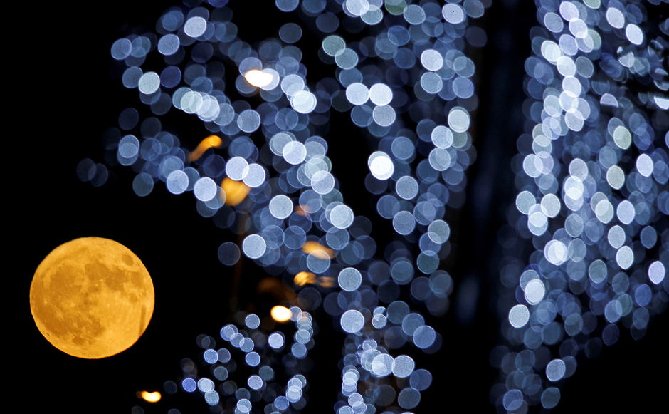The full moon is pictured behind Christmas lights in Marseille, France. PHOTO: REUTERS