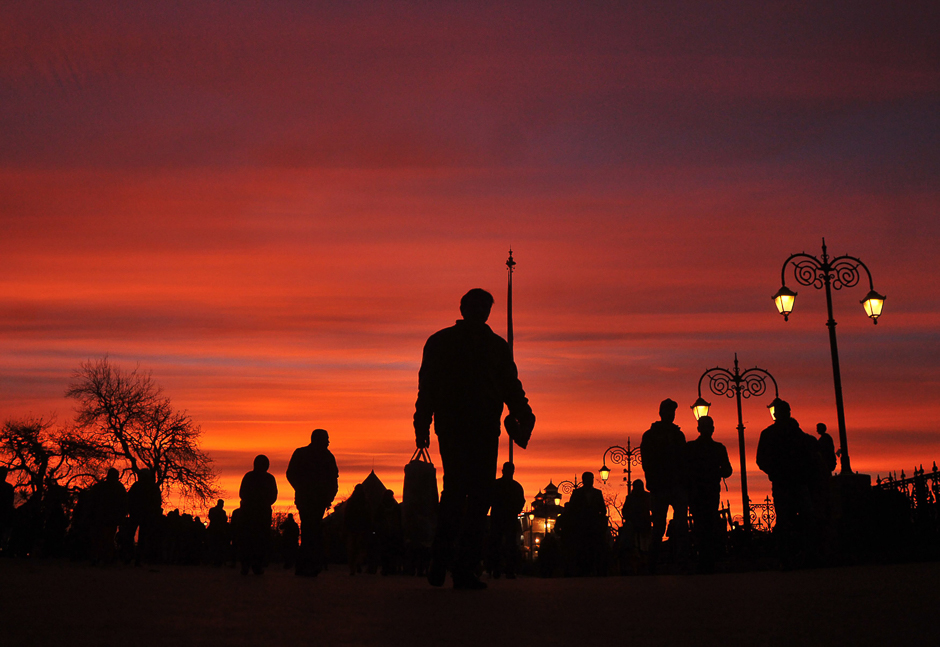 Silhouetted Indian commuters walk during sunset in the northern hill town of Shimla. PHOTO: AFP