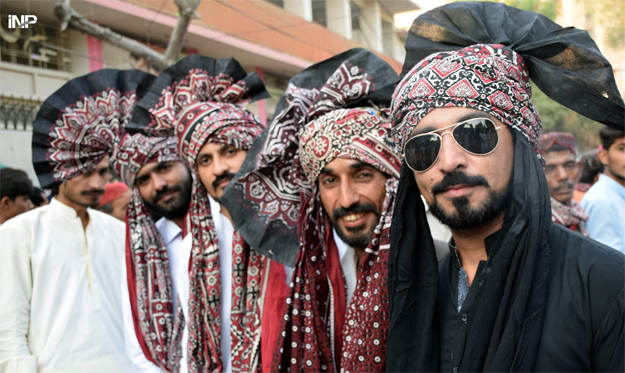 Men wore ajrak to mark the day. PHOTO: INP