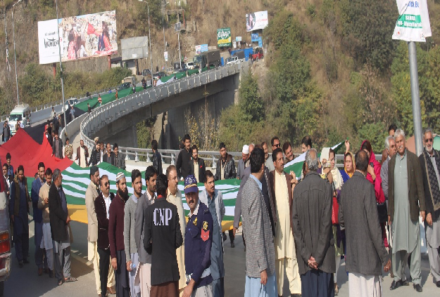 AJK PPP workers carrying the long flag to Parade Ground. PHOTO: EXPRESS
