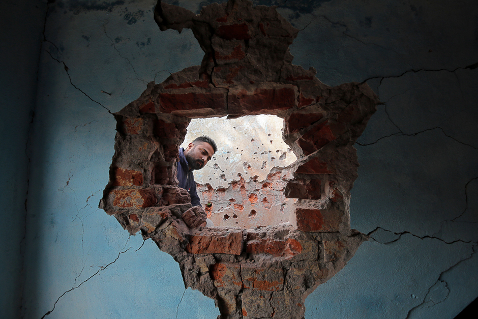 A man looks at the wall of his house that the local residents say was damaged by firing from the Pakistan side of the border at Kanachak in Akhnoor Sector on the outskirts of Jammu. PHOTO: REUTERS