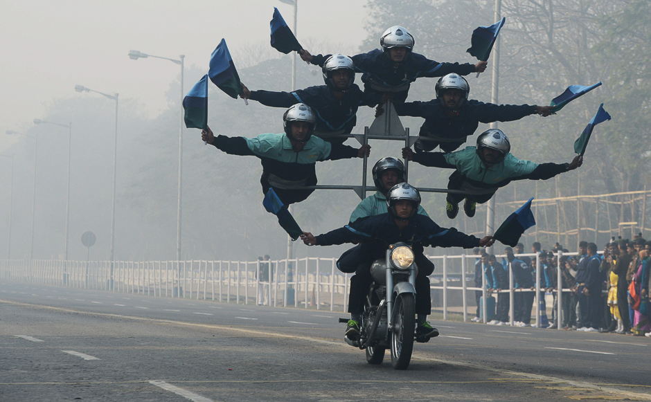 Indian army personnel perform acrobatics on their bikes as they take part in a rehearsal ahead of the forthcoming Republic Day parade in Kolkata. PHOTO: AFP