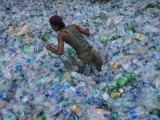 a-worker-uses-a-rope-to-move-through-a-pile-of-empty-plastic-bottles-at-a-recycling-workshop-in-mumbai-2-2