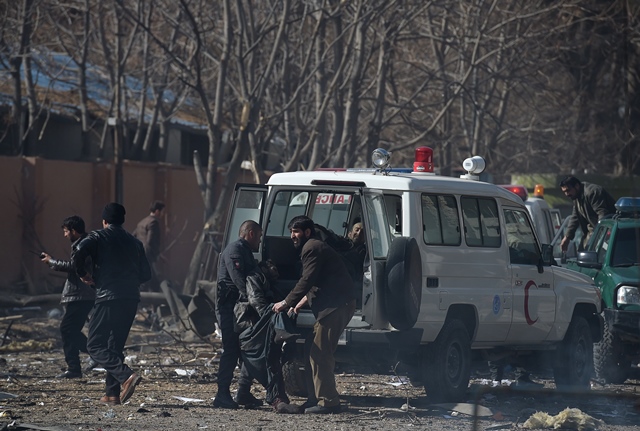 Afghan volunteers and policemen carry injured men on an ambulance at the scene of a car bomb exploded in front of the old Ministry of Interior building in Kabul on January 27, 2018. PHOTO: REUTERS