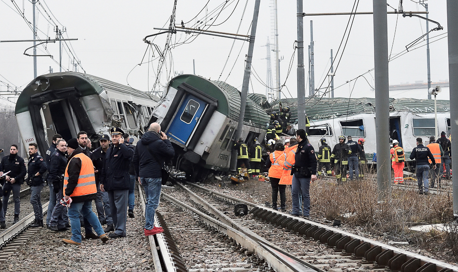 Rescue workers and police officers stand near derailed trains in Pioltello, on the outskirts of Milan, Italy. PHOTO: REUTERS