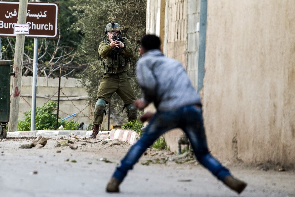 A Palestinian protester confronts an Israeli soldier during an army search operation in the Palestinian village of Burqin in the northern occupied West Bank. PHOTO: AFP