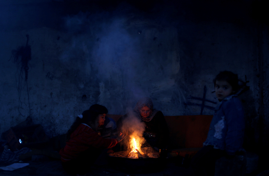 Palestinians warm themselves inside their house in the northern Gaza Strip. PHOTO: REUTERS