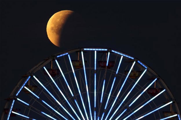 A lunar eclipse of a full blue moon is seen above the ferris wheel on the Santa Monica Pier. PHOTO: REUTERS/Lucy Nicholson 