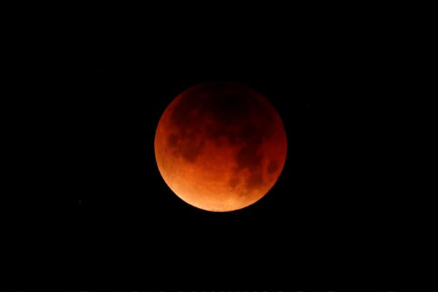 A lunar eclipse over Oceanside, California. PHOTO: REUTERS/Mike Blake 
