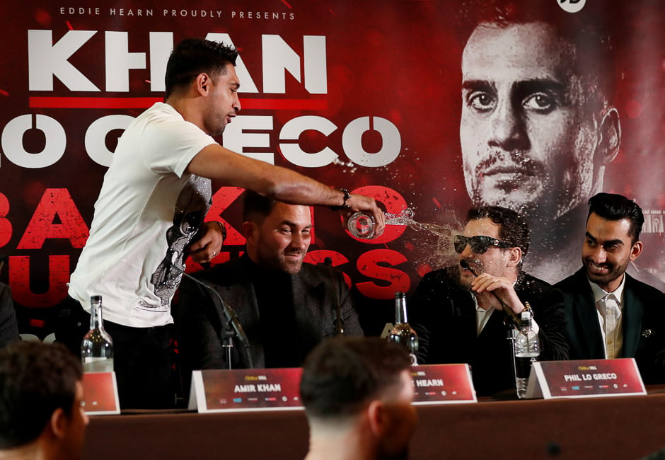 Amir Khan throws water into the face of Phil Lo Greco during the press conference as promoter Eddie Hearn looks on, Liverpool, Britan. PHOTO: REUTERS