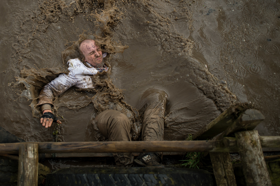A competitor dressed in a white suit falls into muddy water as he negotiates an obstacle in the Tough Guy endurance event near Wolverhampton, central England. PHOTO: AFP