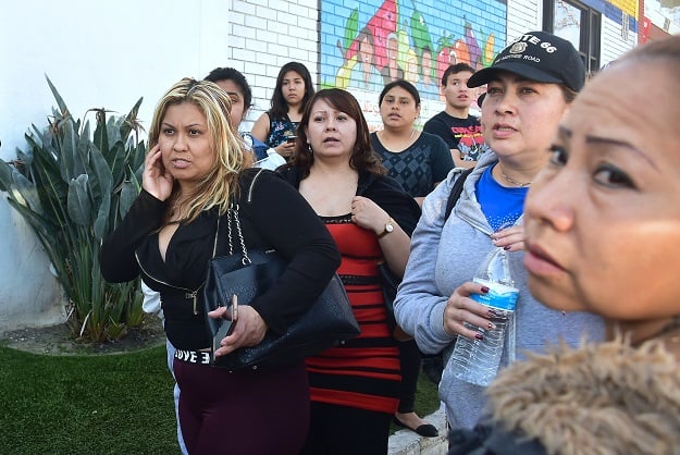 Parents wait and listen for any news from outside a roadblock to Salvadore Castro Middle School in Los Angeles, California. PHOTO:AFP