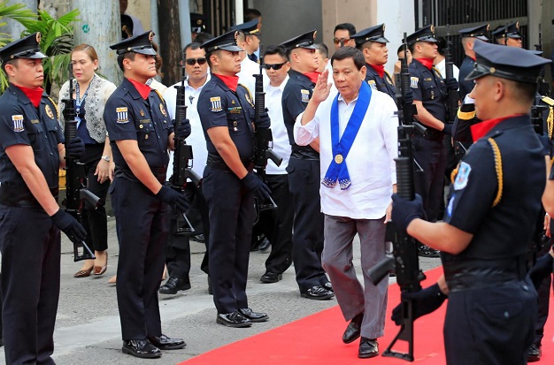 President Rodrigo Duterte salutes while passing members of custom police, upon arrival to witness the destruction of condemned smuggled luxury cars worth 61,626,000.00 pesos (approximately US$1.2 million), which include used Lexus, BMW, Mercedes-Benz, Audi, Jaguar and Corvette Stingray, during the 116th Bureau of Customs founding anniversary in Metro Manila, Philippines February 6, 2018. REUTERS/Romeo Ranoco