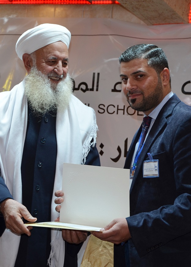 Ibrahim al-Mashhadani, an Iraqi Muslim cleric distributes certificates during a graduation ceremony of the Muslim Scholars Forum of Mosul in the northern Iraqi city on February 8, 2018. PHOTO:AFP