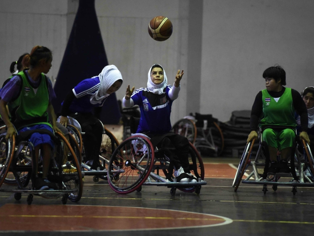 A member of Afghanistan's women's wheelchair basketball team (in blue) plays against Thailand during a training session in the coastal province of Chonburi. PHOTO: AFP