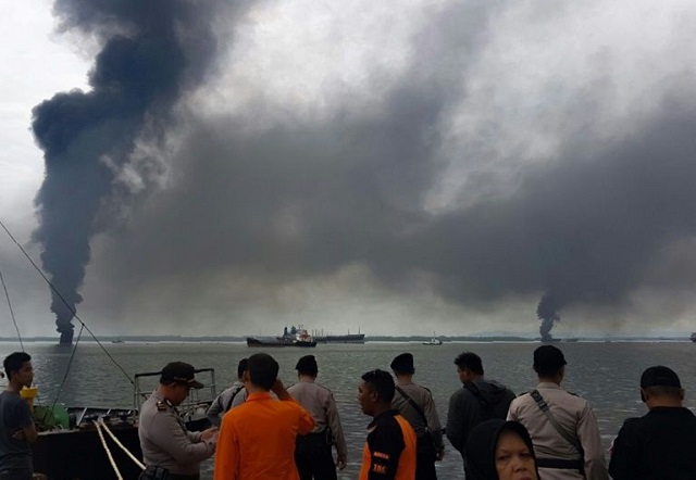 the blaze was sparked as workers tried to clear the spill in waters near balikpapan city by burning it two people   believed to be fishermen   were caught in the fire and died photo afp