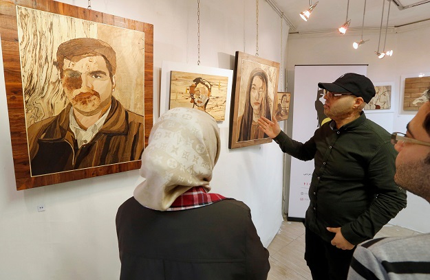 Victims of acid attack present their work at the Ashianeh gallery in Tehran on February 28, 2018 to raise awareness and money. PHOTO: AFP
