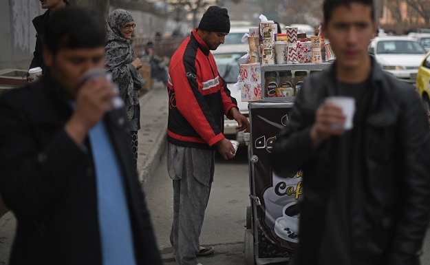 File photo of Najibullah Sharyari with customers at his coffee cart in Kabul, January 8, 2018. PHOTO: AFP/ File