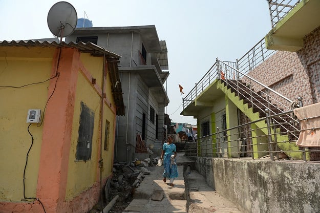 This photo taken on March 9, 2018 shows a woman walking through an alley in a village on Elephanta Island near Mumbai. Hundreds of villagers on the UNESCO heritage-listed island of Elephanta have had mains electricity installed in their houses for the first time. Local officials hope tourists, who take a short boat ride from the bustle of Mumbai to visit the island's famed fifth century caves, will now spend more time and money there, boosting local businesses and jobs. PHOTO:AFP