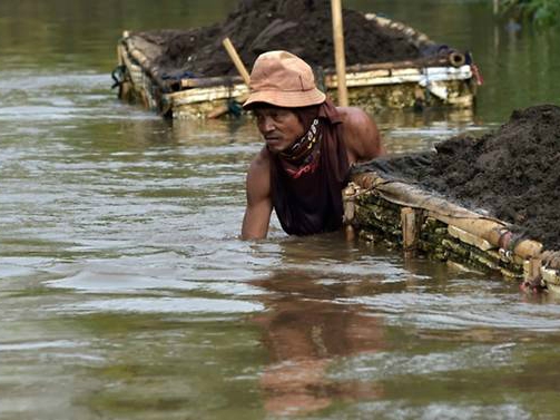 A man mines sand in the Citarum river in Majalaya, West Java. PHOTO: AFP