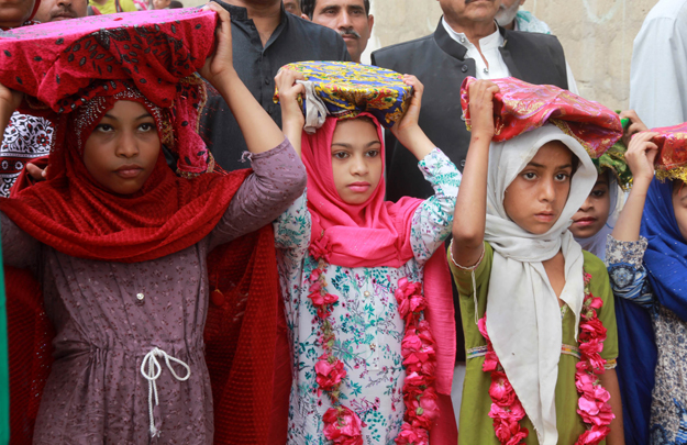 Girls balanced tray of sweets on their heads. PHOTO: ATHAR KHAN