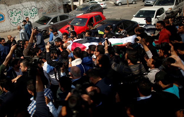 Colleagues of Palestinian journalist Yasser Murtaja, killed by Israeli fire, carry his body during his funeral in Gaza city. PHOTO: REUTERS 