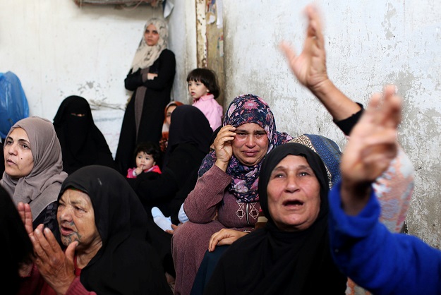 Relatives of Palestinians killed by Israeli fire react. PHOTO: REUTERS 