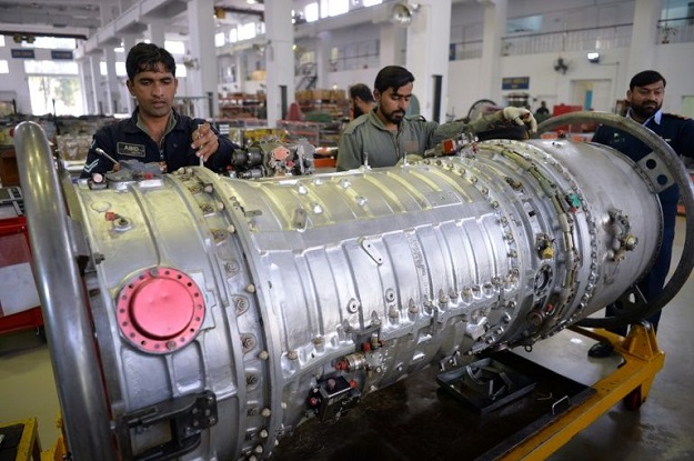 In this picture taken on December 27, 2017, technicians work on the engine of a Mirage aircraft being serviced by the Pakistan Air Force (PAF) at the Mirage Rebuild Factory (MRF) in Kamra, west of the capital Islamabad. PHOTO: AFP