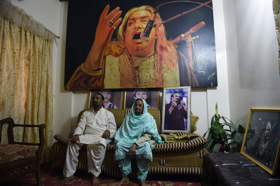 Qawwali singer Talha Sabri (L) is flanked by his mother as he speaks during an interview with AFP behind an image of his late father and renowned Qawwal Ghulam Farid Sabri at his residence in Karachi. PHOTO: AFP