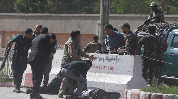 Policemen help Afghan journalists, victims of a second blast. PHOTO: REUTERS