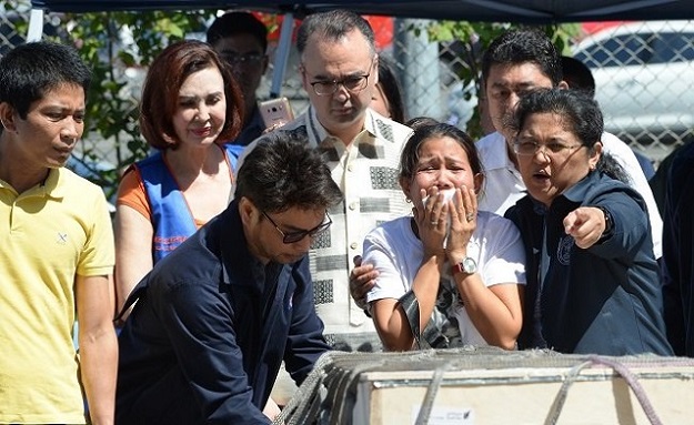 Jessica Demafelis, the sister of murdered Filipina maid Joanna Demafelis who was found dead in a freezer in Kuwait, cries as the wooden casket of her sisters remains at the Ninoy Aquino International Airport in suburban Pasay city, southeast of Manila, Philippines, Feb 16, 2018. PHOTO: AFP