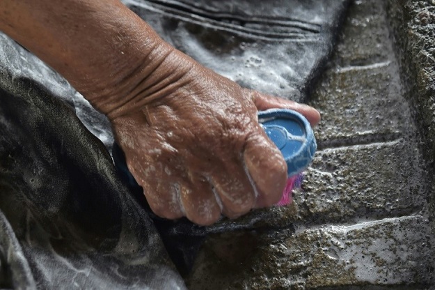 Washerwomen rub dirty clothes against rough stones at an old public laundry in Quito. PHOTO: AFP