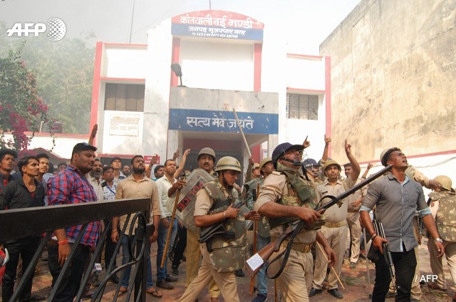 Indian police stand guard as protesting members of 'low caste' groups throw stones at their station in Uttar Pradesh state. PHOTO: AFP