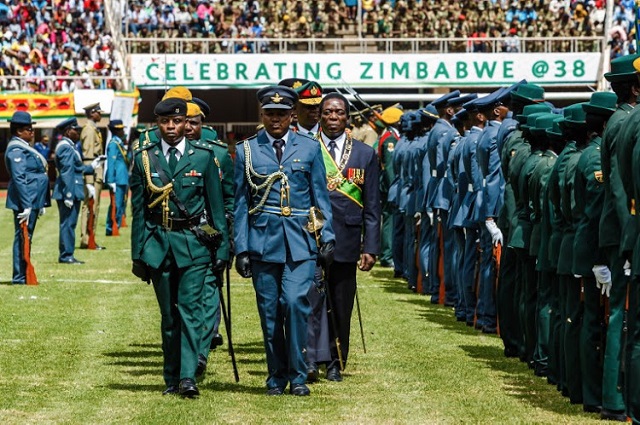 President Emmerson Mnangagwa (C-R) inspects a military guard of honour during Independence Day celebrations. PHOTO: AFP