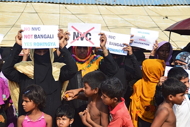 Rohingya refugees hold placards to members of United nations Security Council team during their visit to Kutupalong refugee camp in Bangladesh's Ukhia's district on 29 April 2018. PHOTO: AFP