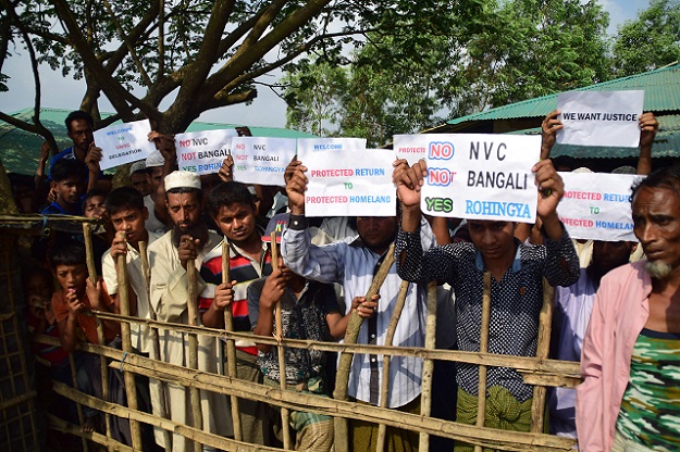 Rohingya refugees hold placards to members of United nations Security Council team. PHOTO: AFP