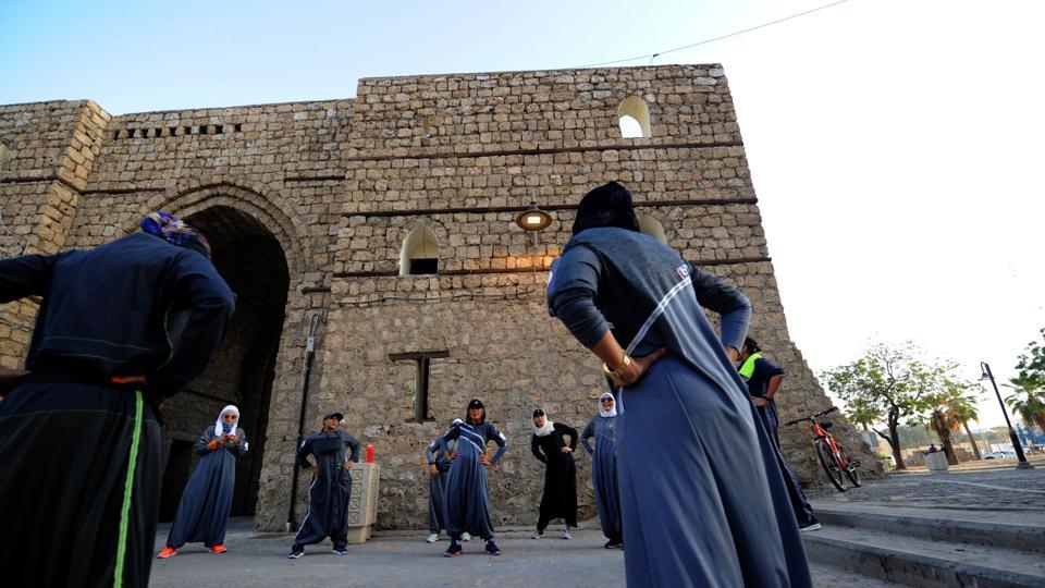 Saudi women stretch before a jog in Jeddah's historic al-Balad district on March 8, 2018. PHOTO: AFP