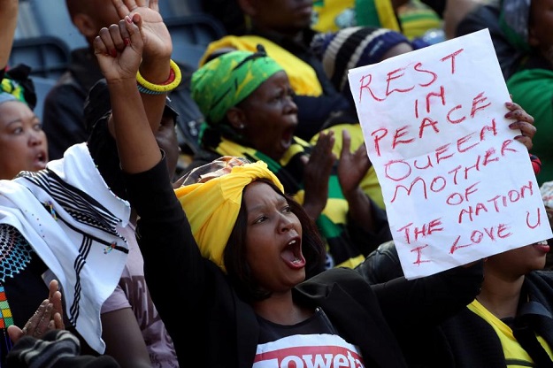 A woman holds a banner and cheers during eulogies at Winnie Madikizela-Mandela's funeral in Orlando stadium in Soweto, South Africa, April 14, 2018. PHOTO: REUTERS