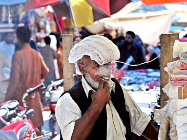 a local vendor takes a drag from his cigarette photo afp