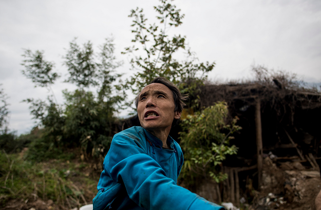 This picture taken on April 21, 2018 shows villager Wang Guocheng posing in the remains of his home in the old village of Luobozhai (Radish Village), which was damaged during the 2008 Sichuan earthquake, in Wenchuan county, Sichuan province. The village, on a small plateau near the top of a mountain, was badly damaged in the earthquake and most of the villagers moved to a new village nearby. PHOTO: AFP