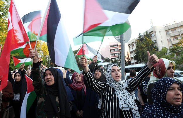 Protesters chants slogans as they hold Palestinian and Turkish flags outside the residence of the Israeli Ambassador in Ankara on May 14, 2018 during a demonstration against US President Donald Trump's decision to move the US embassy from Tel Aviv to Jerusalem PHOTO: AFP