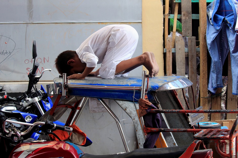 A Filipino Muslim boy prays on the top of a motorcycle cab, during the second day of Ramadan, outside a mosque in Baseco, Tondo City, Metro Manila, Philippines May 18, 2018. PHOTO: REUTERS