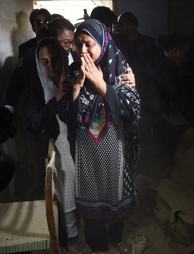 Asma Nawab (C) reacts as she enters her house after her release in Karachi. PHOTO: AFP