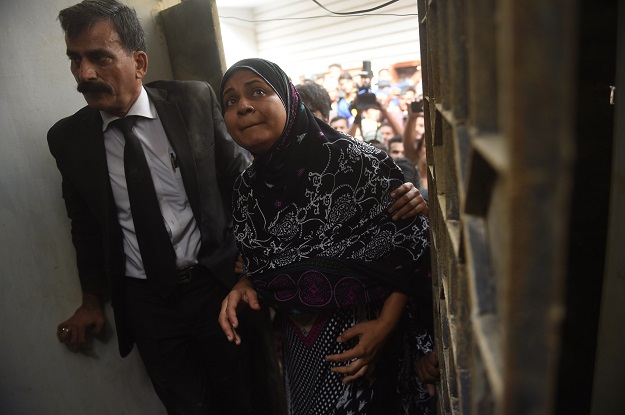 Asma Nawab (R) and her lawyer Javed Chatari enter her house after her release in Karachi. PHOTO: AFP